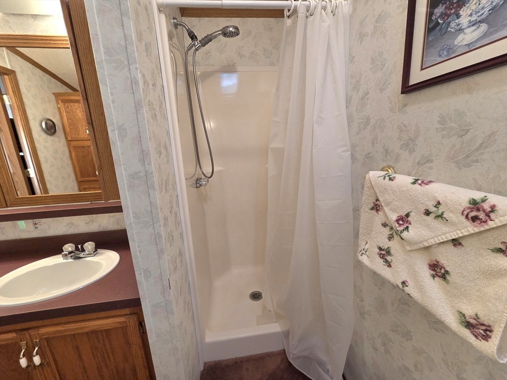 268 Palmer Road, Unit 59 Monson, MA 01057 - Photo 14 of 27 a bathroom with a sink and a mirror