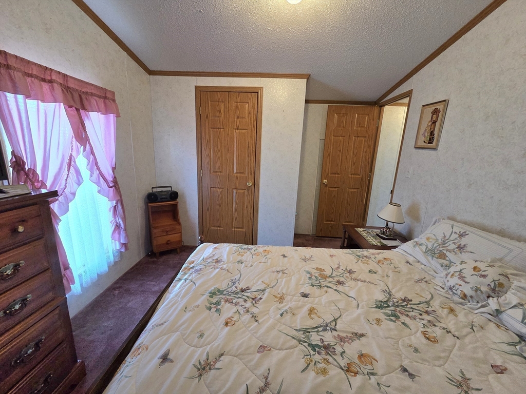 268 Palmer Road, Unit 59 Monson, MA 01057 - Photo 19 of 27 a bedroom with a bed dresser and a flat tv screen