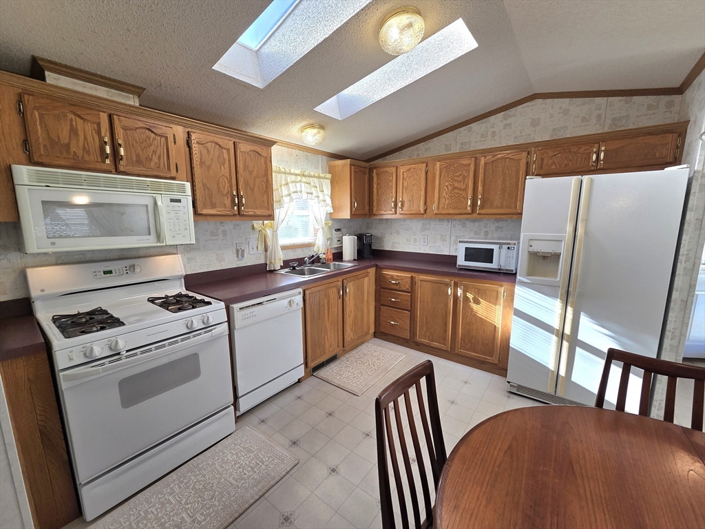 268 Palmer Road, Unit 59 Monson, MA 01057 - Photo 6 of 27 a kitchen with stainless steel appliances granite countertop a stove a sink dishwasher and a refrigerator