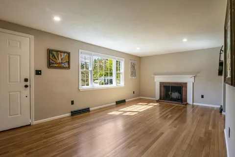 wooden floor fireplace and windows in an empty room