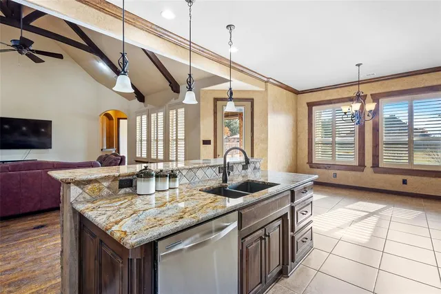 a kitchen with stainless steel appliances granite countertop a sink a stove and a wooden floor