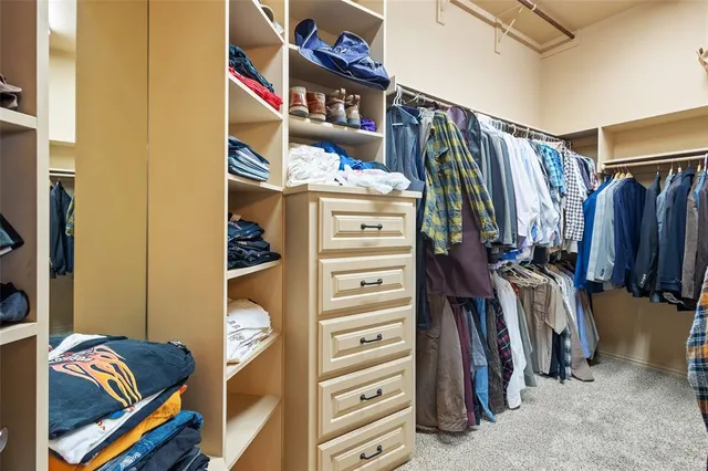 a view of walk in closet with clothes and shoes