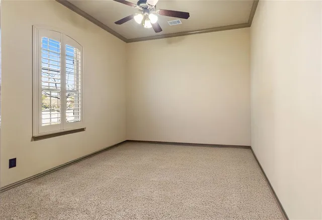 an empty room with windows and chandelier fan