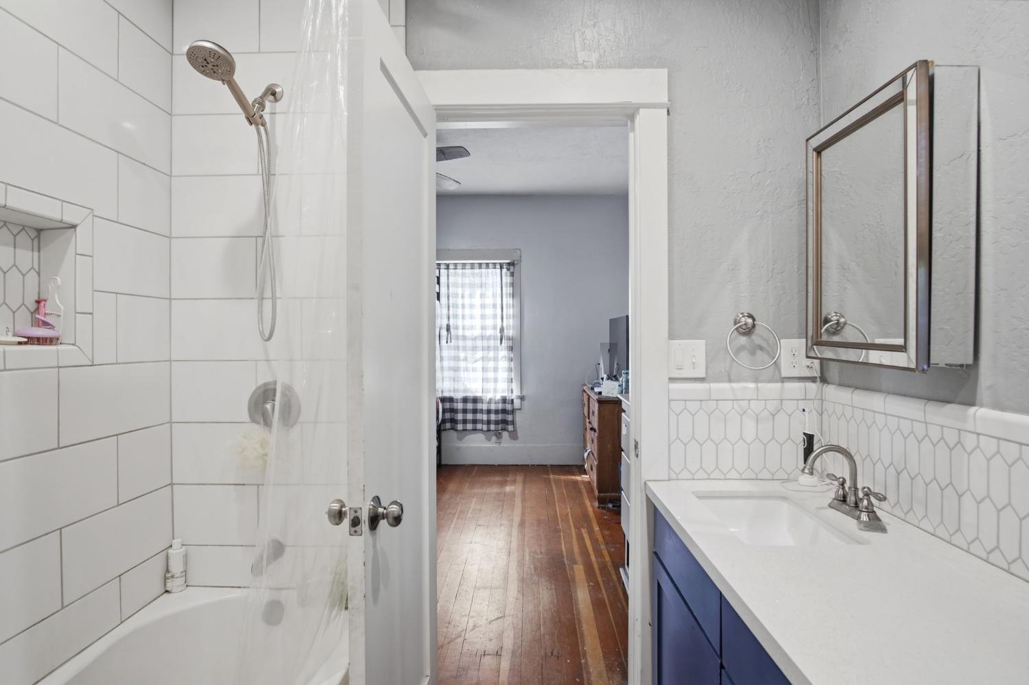 557 Florence Street Turlock, CA 95380 - Photo 15 of 36 a bathroom with a granite countertop sink a mirror and shower