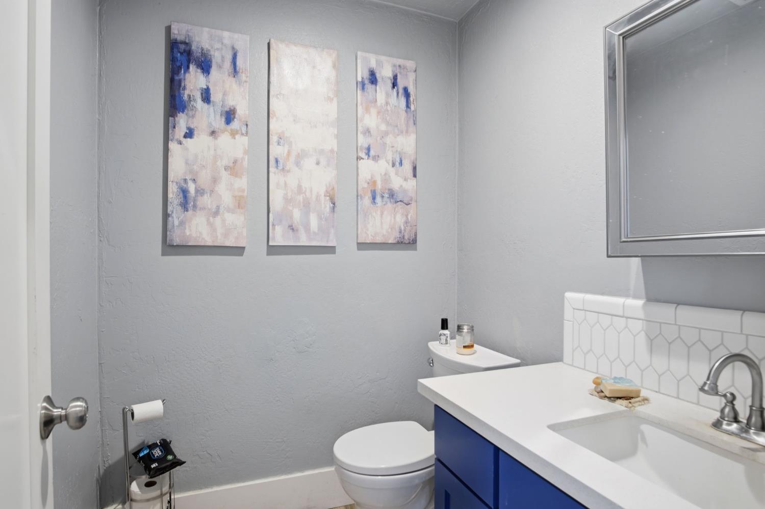 557 Florence Street Turlock, CA 95380 - Photo 16 of 36 a bathroom with a sink a toilet and a mirror