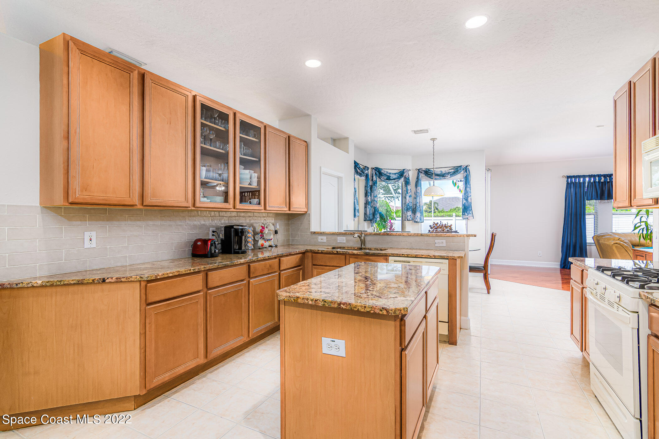 3832 Stream Drive Melbourne, FL 32940 - Photo 12 of 63 a kitchen with stainless steel appliances granite countertop a stove a sink and a microwave