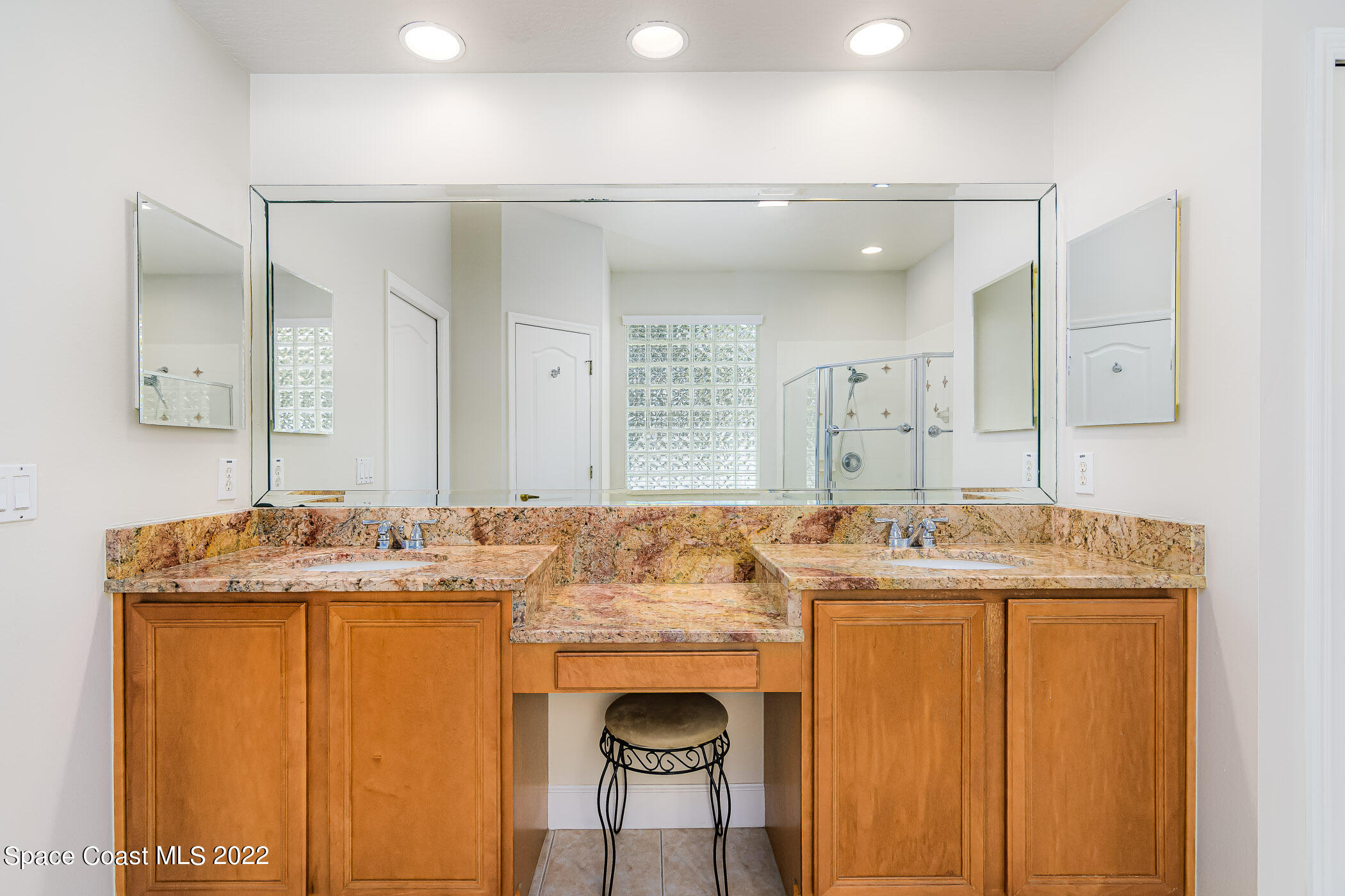 3832 Stream Drive Melbourne, FL 32940 - Photo 21 of 63 a bathroom with a granite countertop sink a toilet a mirror and shower