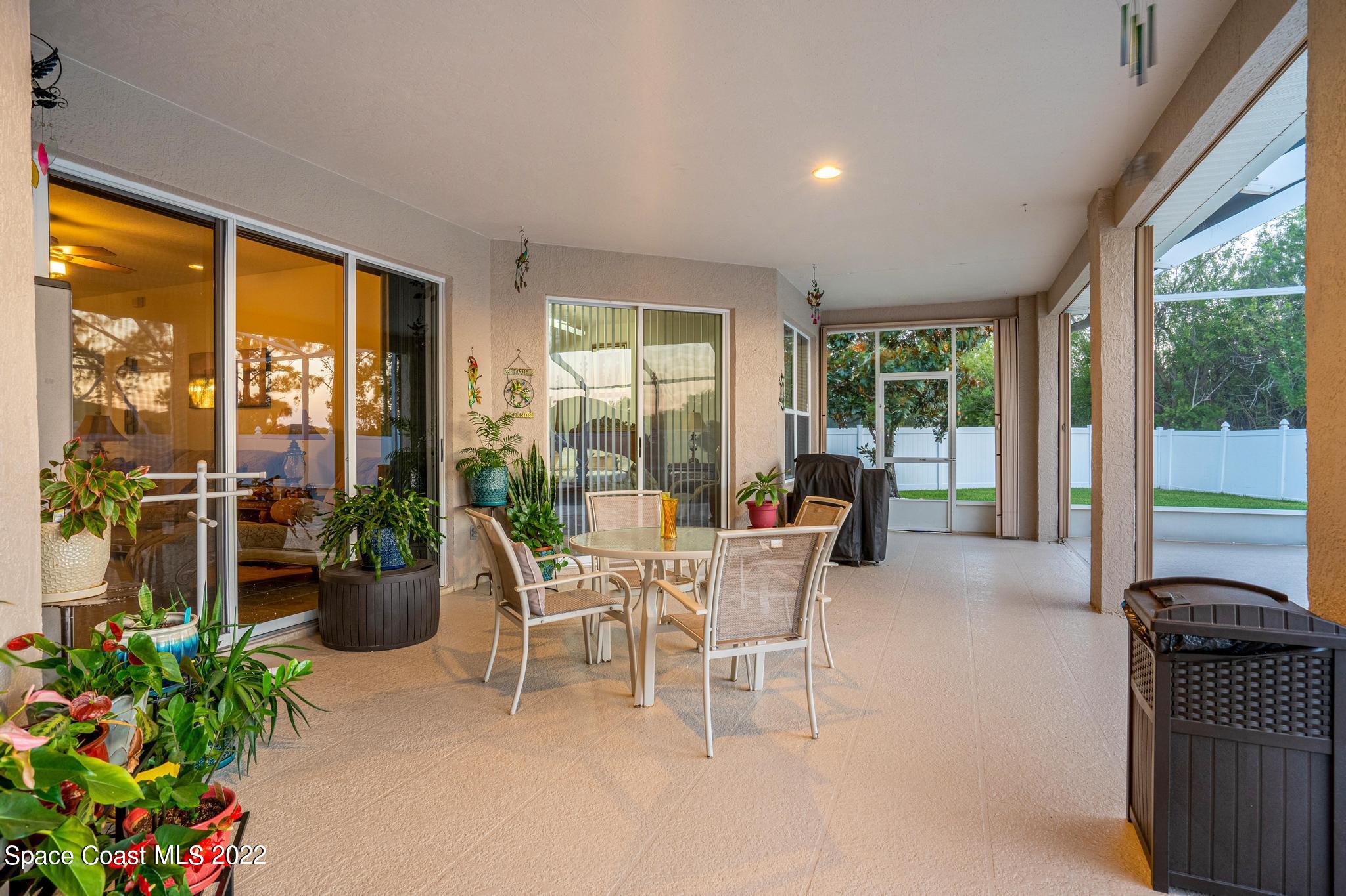 3832 Stream Drive Melbourne, FL 32940 - Photo 35 of 63 a living room with furniture potted plant and a floor to ceiling window