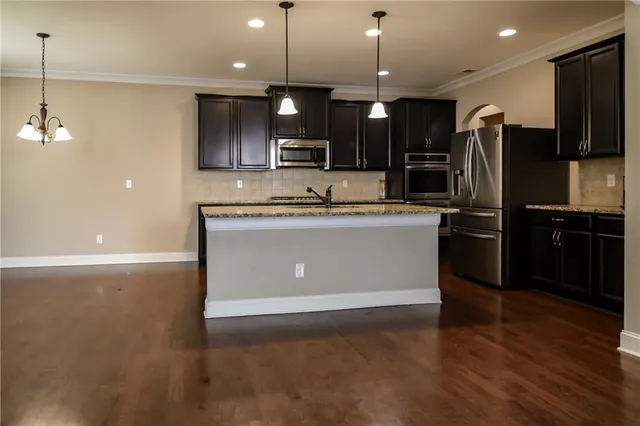 a kitchen with stainless steel appliances granite countertop a sink a stove and a refrigerator