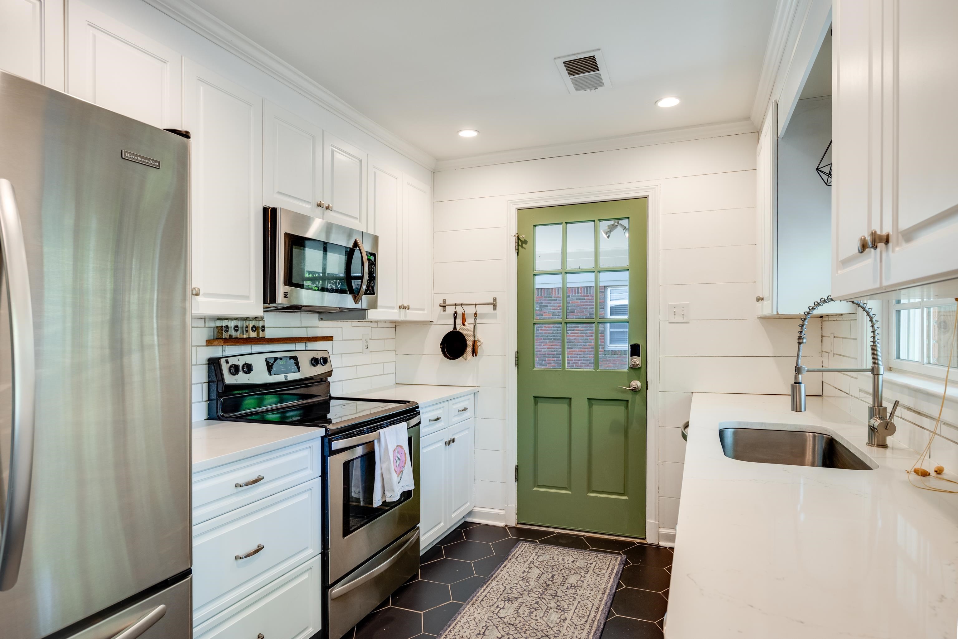 1089 West Perkins Road Memphis, TN 38117 - Photo 9 of 25 a kitchen with white cabinets and stainless steel appliances