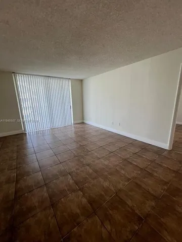 a view of a livingroom with an empty space and a window