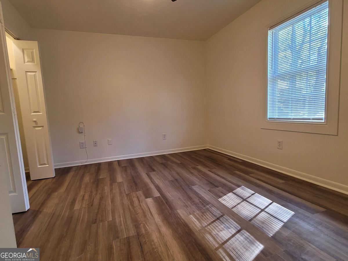 47 West New Street, Unit A Winder, GA 30680 - Photo 16 of 28 an empty room with wooden floor and windows