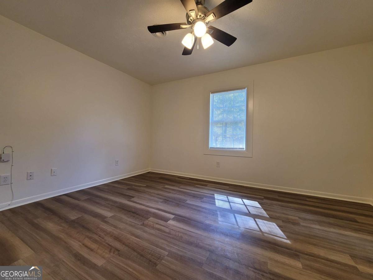 47 West New Street, Unit A Winder, GA 30680 - Photo 17 of 28 a view of an empty room with wooden floor and a window