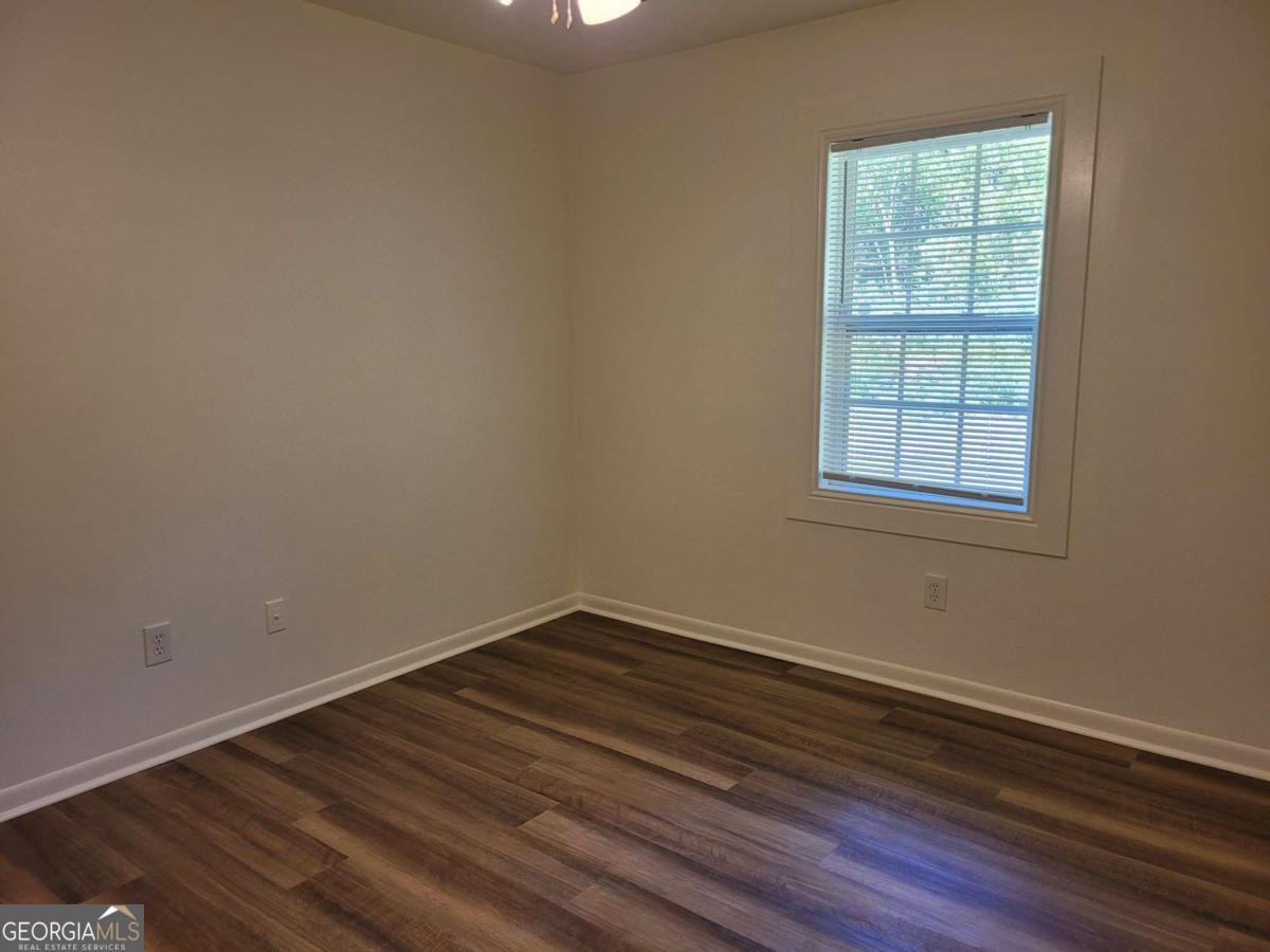 47 West New Street, Unit A Winder, GA 30680 - Photo 24 of 28 an empty room with wooden floor and windows