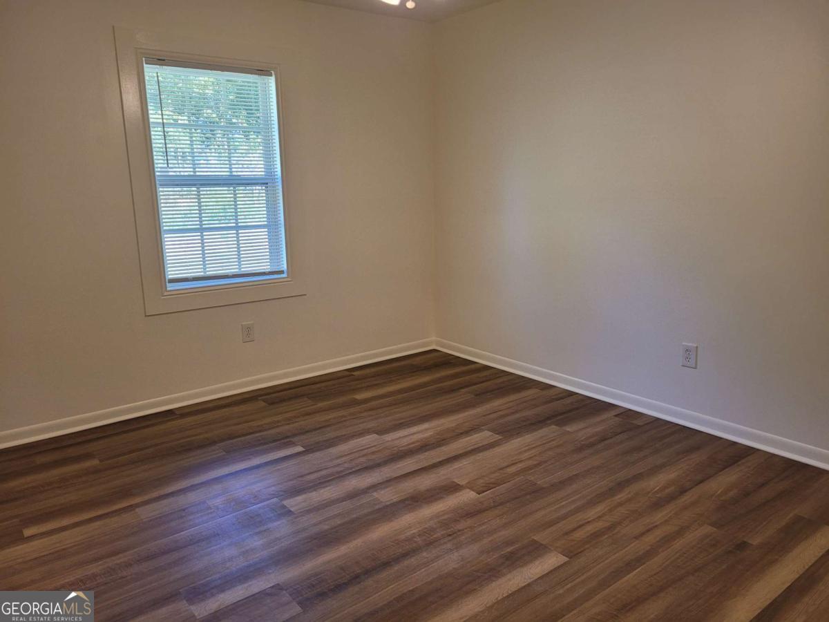 47 West New Street, Unit A Winder, GA 30680 - Photo 25 of 28 an empty room with wooden floor and windows