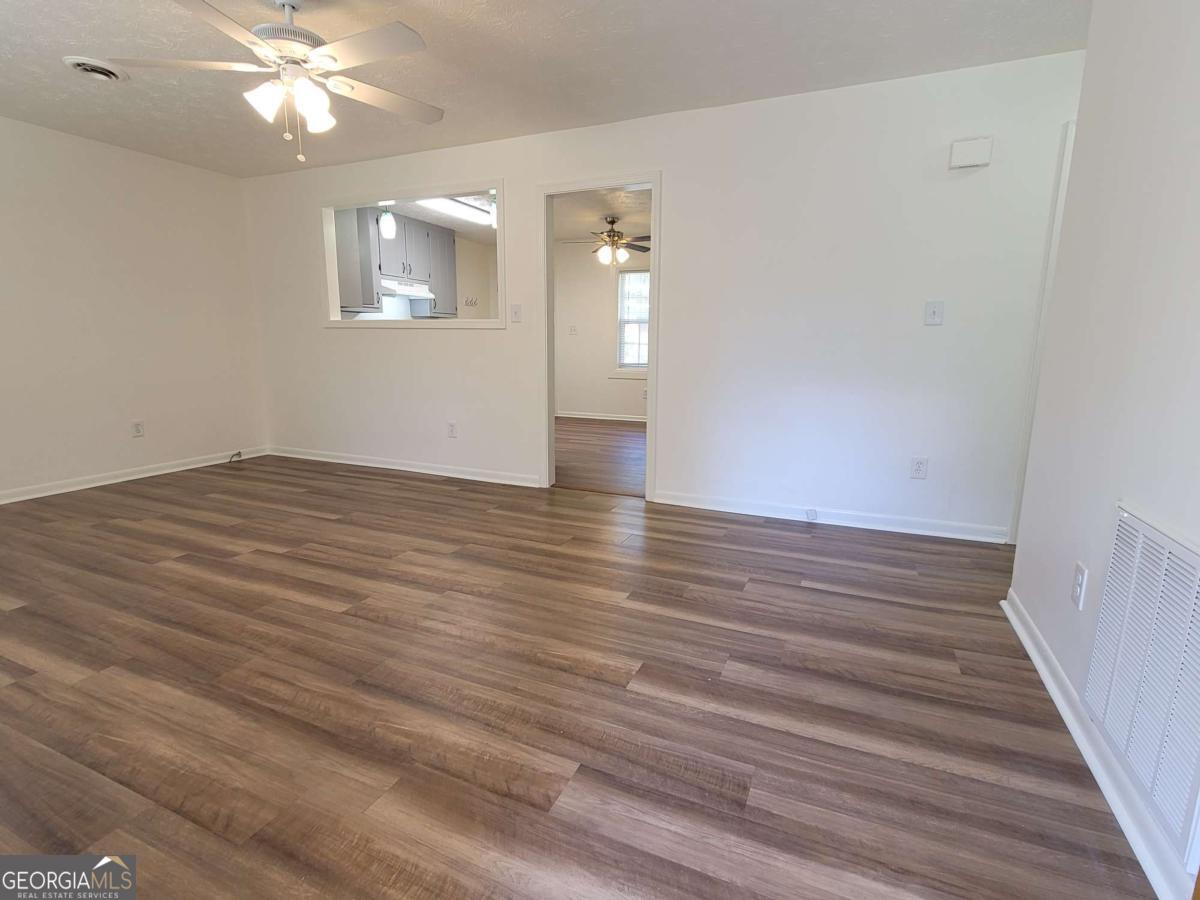 47 West New Street, Unit A Winder, GA 30680 - Photo 6 of 28 wooden floor in an empty room with a window