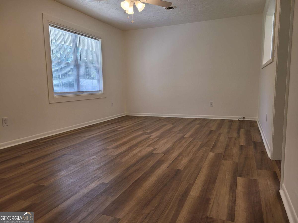 47 West New Street, Unit A Winder, GA 30680 - Photo 8 of 28 a view of an empty room with wooden floor and a window