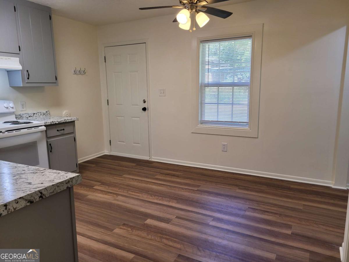 47 West New Street, Unit A Winder, GA 30680 - Photo 10 of 28 an empty room with wooden floor cabinet and windows