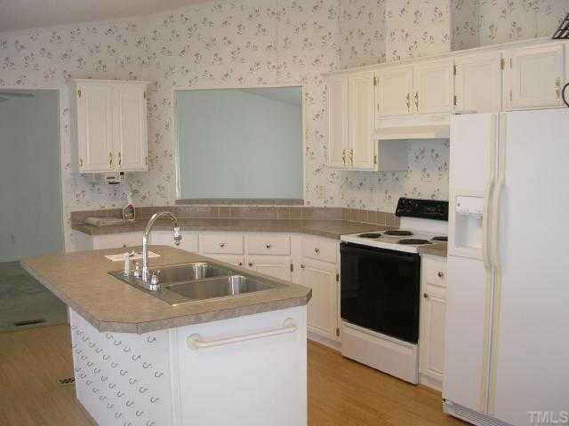 63 Dustin Lane Roxboro, NC 27574 - Photo 4 of 8 a kitchen with granite countertop a sink stove and cabinets