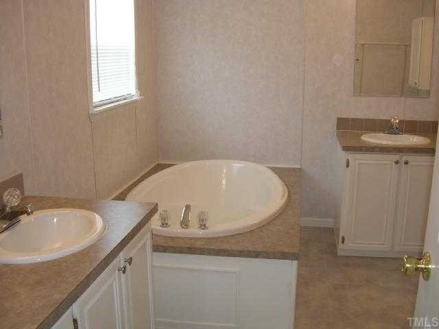 63 Dustin Lane Roxboro, NC 27574 - Photo 7 of 8 a bathroom with a granite countertop sink and a mirror