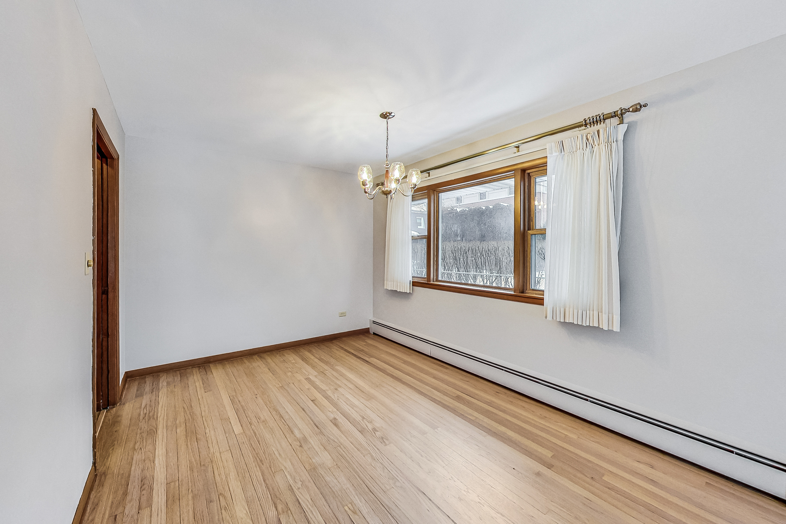 1108 Tyrell Avenue Park Ridge, IL 60068 - Photo 5 of 32 a view of an empty room with wooden floor and a window