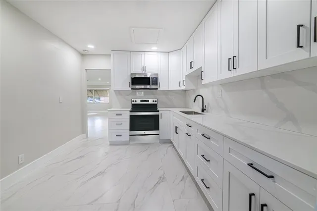 a kitchen with stainless steel appliances white cabinets a sink and dishwasher