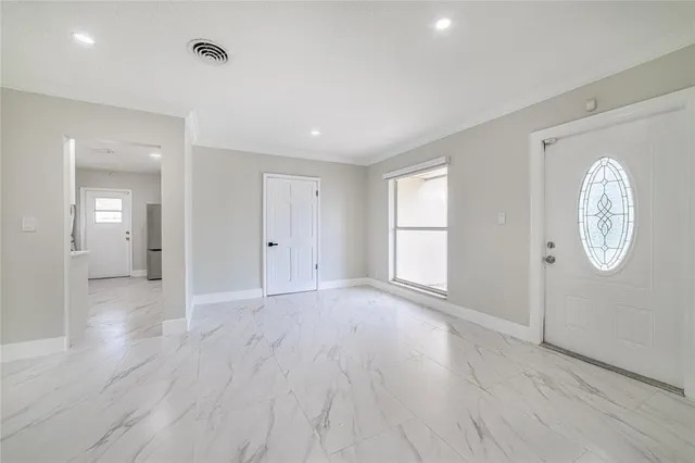a view of an empty room with window and wooden floor