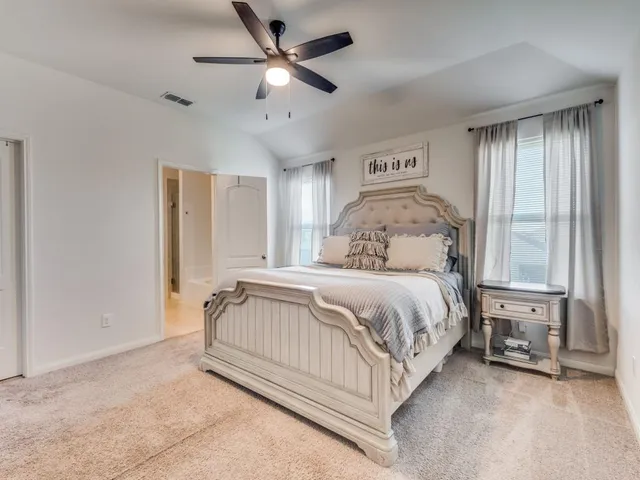 a bedroom with a bed chandelier and a window