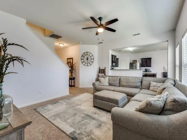 a living room with furniture and a ceiling fan