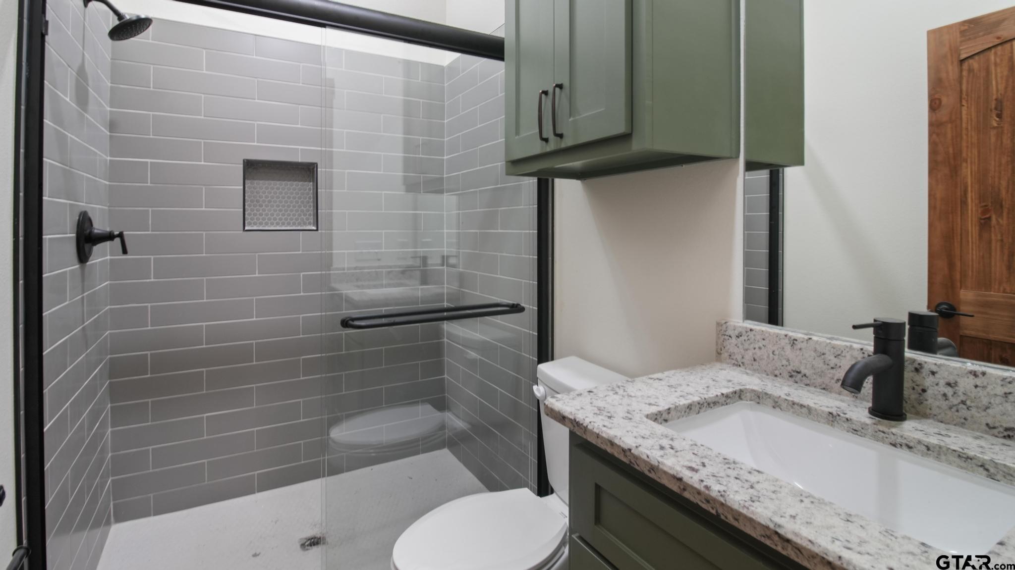22522 Pine Street Flint, TX 75762 - Photo 28 of 39 a bathroom with a granite countertop toilet sink and mirror