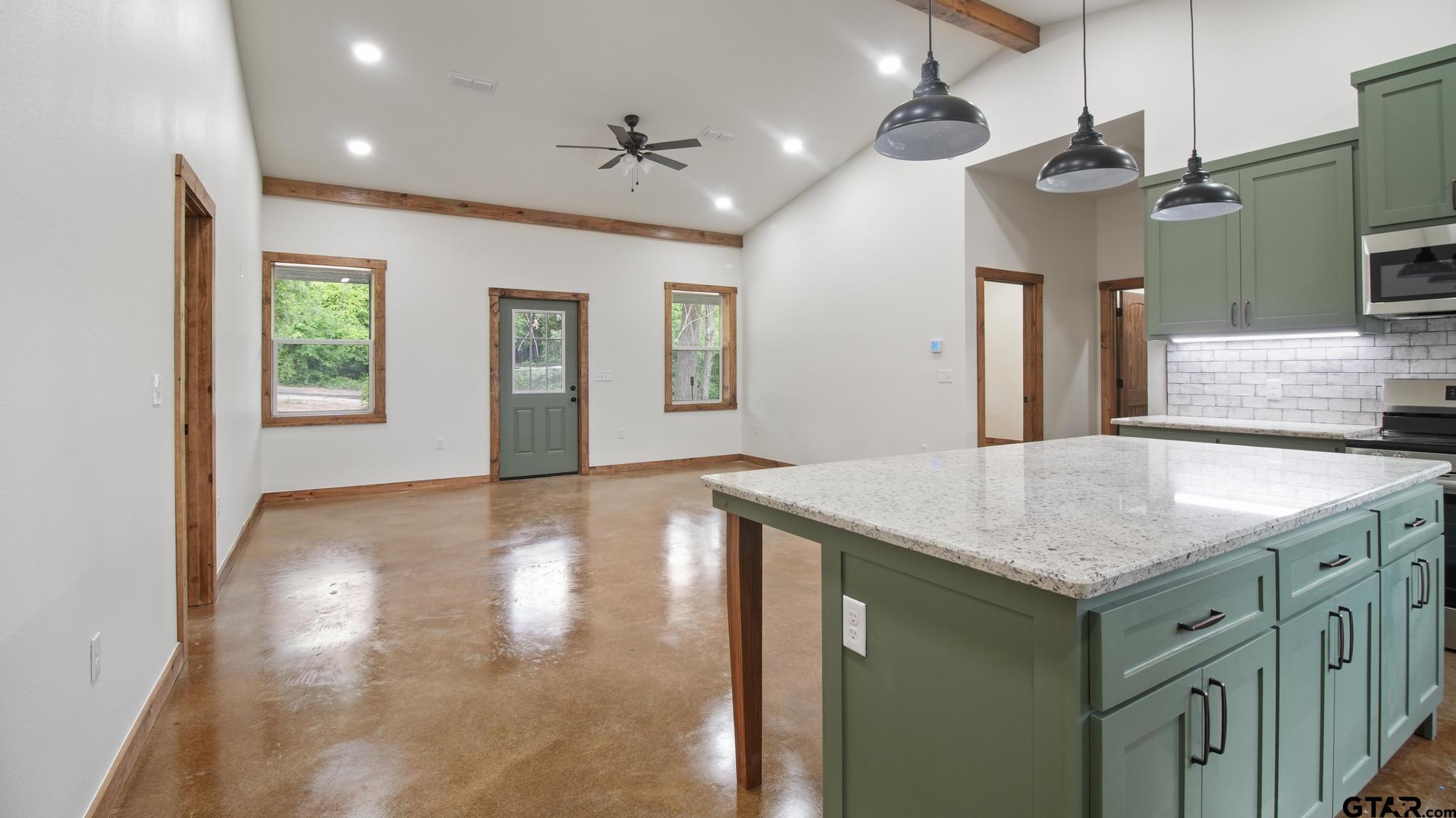 22522 Pine Street Flint, TX 75762 - Photo 6 of 39 a kitchen with kitchen island a sink a center island and stainless steel appliances
