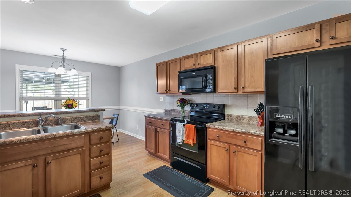 1913 Jenny Road Fayetteville, NC 28314 - Photo 19 of 38 a kitchen with stainless steel appliances granite countertop a stove refrigerator sink and microwave