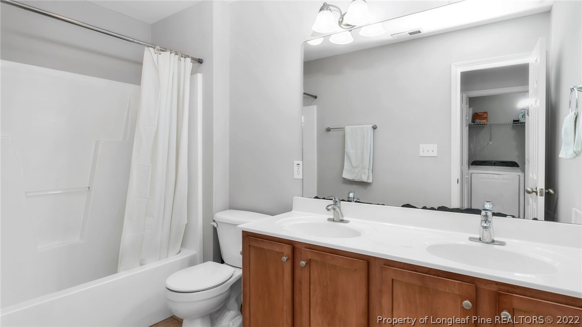 1913 Jenny Road Fayetteville, NC 28314 - Photo 28 of 38 a bathroom with a double vanity sink toilet and a mirror