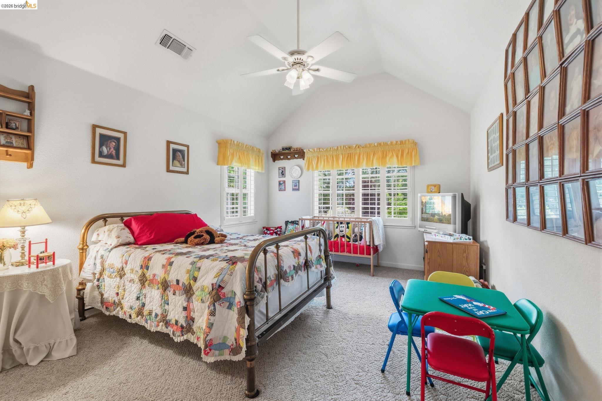 18450 Lambert Lake Road Sonora, CA 95370 - Photo 46 of 87 Vaulted ceiling bedroom featuring white walls, light-colored carpet flooring, two windows with plantation shutters, and a ceiling fan