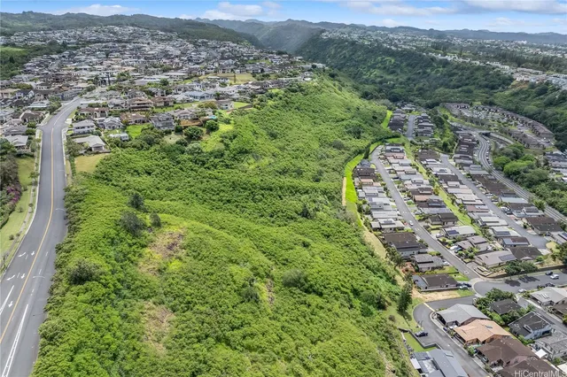 an aerial view of residential houses with outdoor space and trees