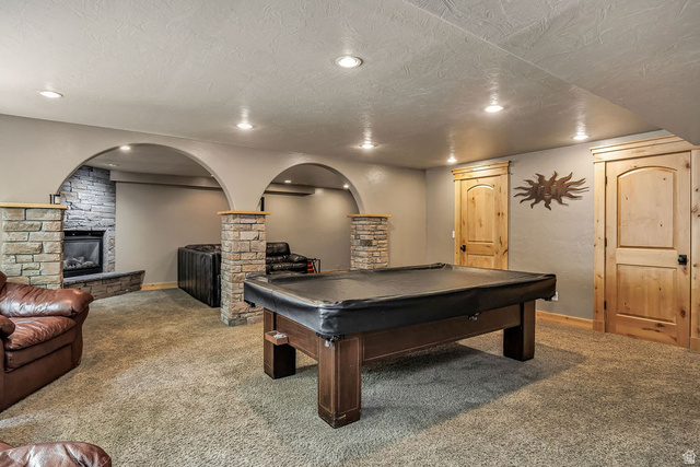 288 525 South Providence, UT 84332 - Photo 26 of 71 Expansive carpeted room featuring a stone fireplace with hearth, recessed lighting, and natural wood doors