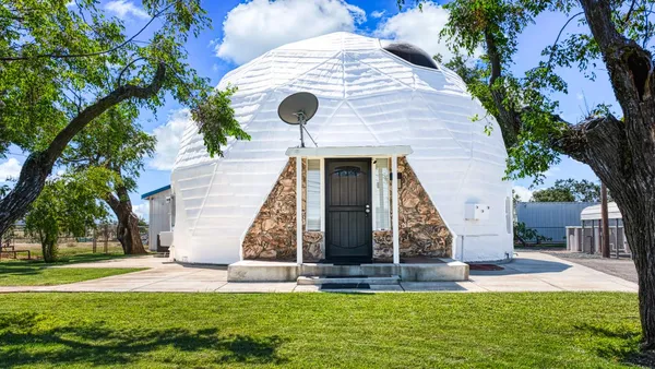 a view of a house with backyard and tree