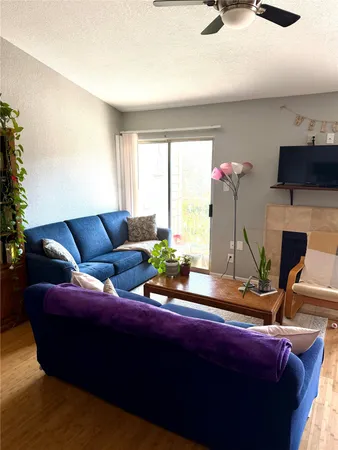 a living room with furniture a flat screen tv and a large window