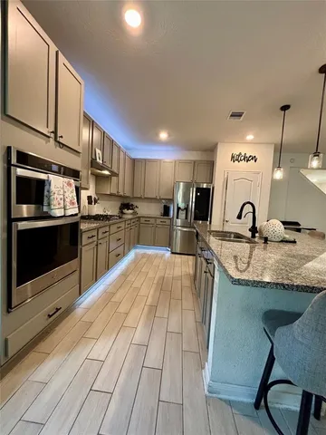 a kitchen with stainless steel appliances granite countertop a sink and cabinets
