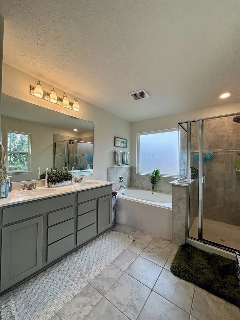 734 Hardwood Grv Court Houston, TX 77090 - Photo 18 of 23 a large bathroom with a tub sink shower and mirror