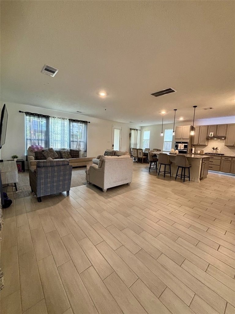 734 Hardwood Grv Court Houston, TX 77090 - Photo 7 of 23 a living room with furniture and a kitchen