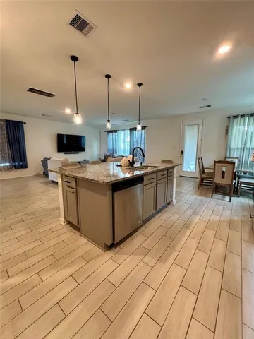 a large kitchen with stainless steel appliances kitchen island granite countertop a sink and cabinets