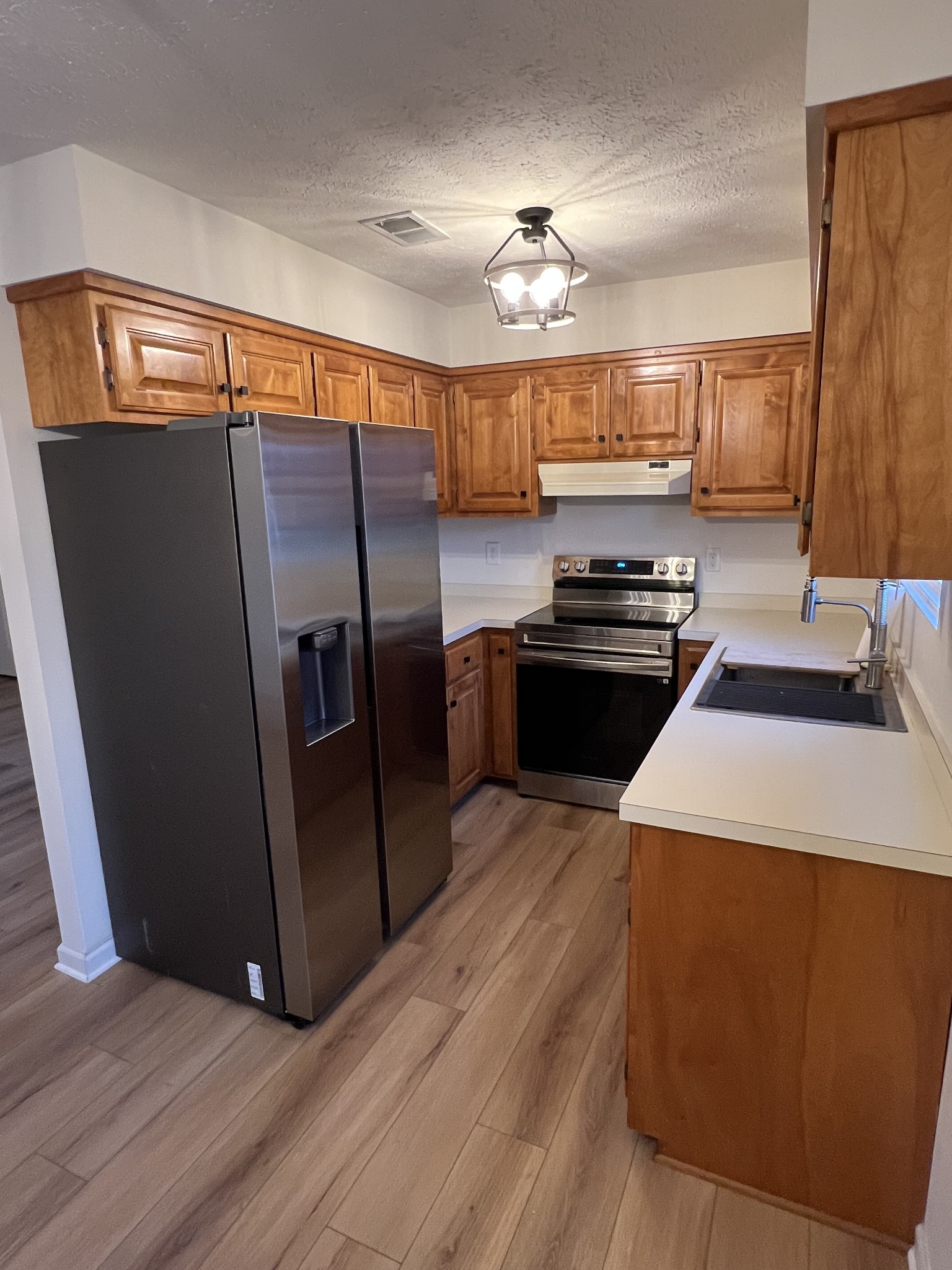 1343 Oaklawn Road Chapmansboro, TN 37035 - Photo 6 of 10 a kitchen with granite countertop a refrigerator a sink a stove and island