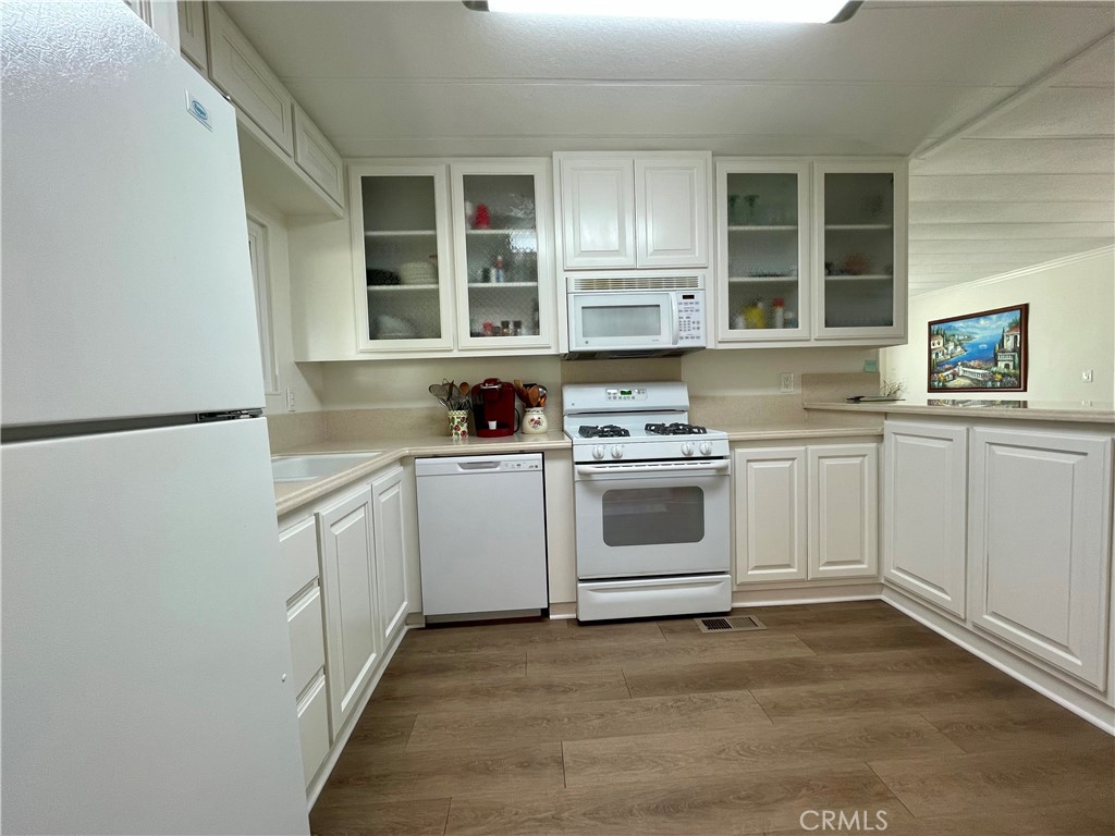 31130 South General Kearny Road, Unit 145 Temecula, CA 92591 - Photo 11 of 27 a kitchen with white cabinets and white appliances