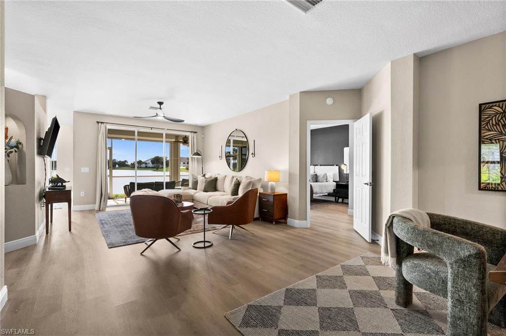 6080 Pinnacle Lane, Unit 1701 Naples, FL 34110 - Photo 12 of 39 a living room with furniture a lamp and a dining table with wooden floor