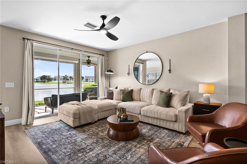 6080 Pinnacle Lane, Unit 1701 Naples, FL 34110 - Photo 13 of 39 a living room with furniture and a large window