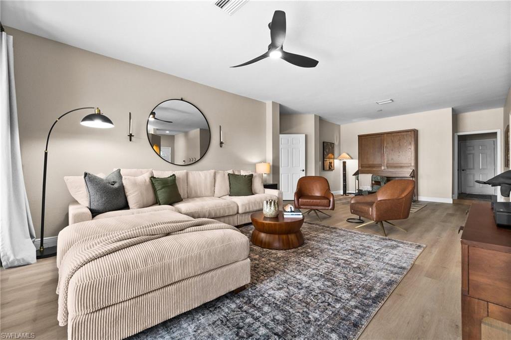 6080 Pinnacle Lane, Unit 1701 Naples, FL 34110 - Photo 14 of 39 a living room with furniture a ceiling fan and a rug
