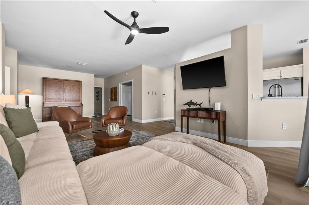 6080 Pinnacle Lane, Unit 1701 Naples, FL 34110 - Photo 15 of 39 a bedroom with a bed and a flat screen tv