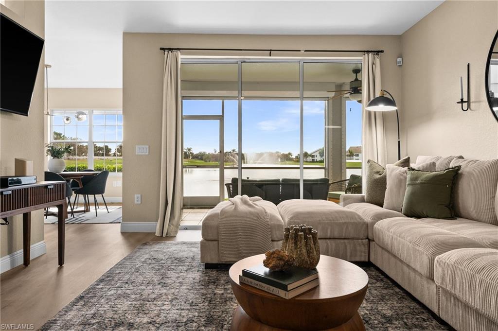 6080 Pinnacle Lane, Unit 1701 Naples, FL 34110 - Photo 18 of 39 a living room with furniture and a floor to ceiling window