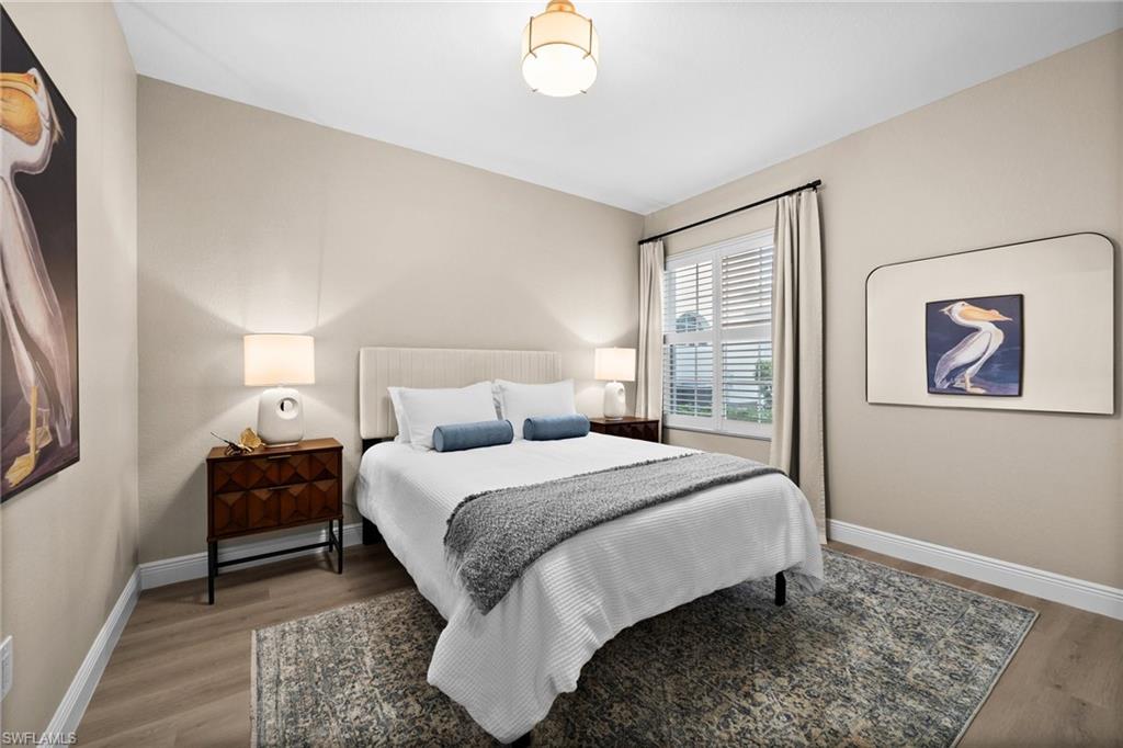 6080 Pinnacle Lane, Unit 1701 Naples, FL 34110 - Photo 26 of 39 a bedroom with a bed and a painting on the wall
